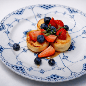 Syrniki with berries and yuzu caramel